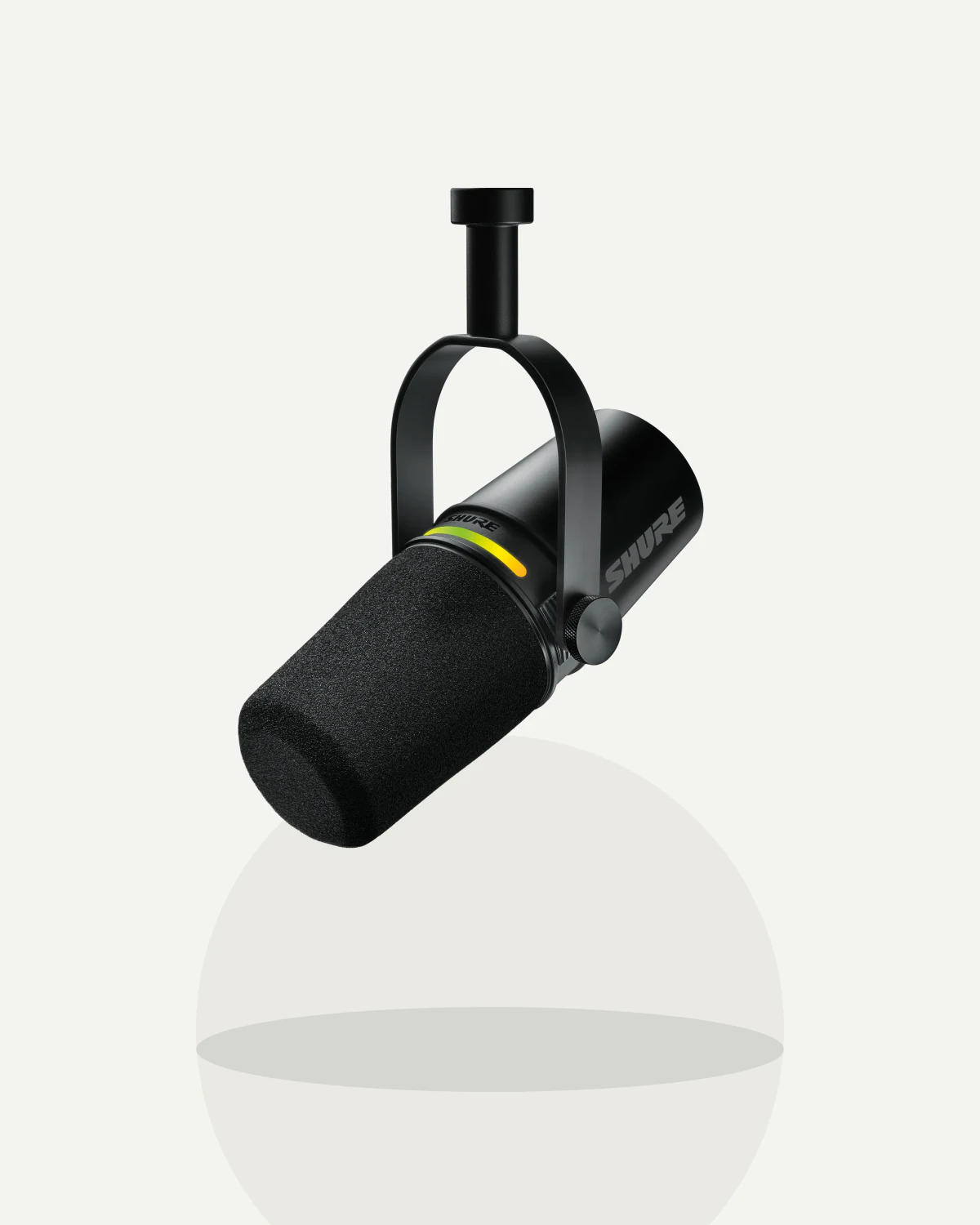 A black Shure MV7+ podcast microphone on a clean off-white product background.