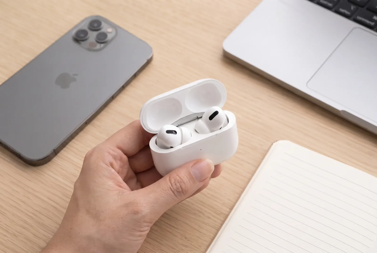 A charging case held naturally in one hand to make the compact product scale immediately clear.