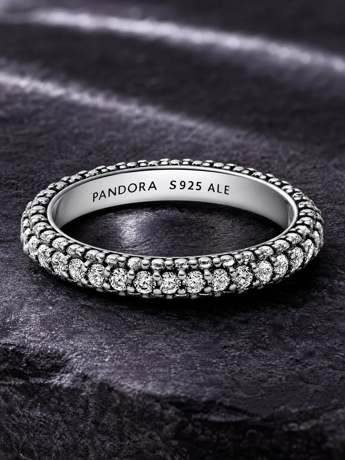 A silver pavé ring shown close enough to inspect its band profile and stone setting.