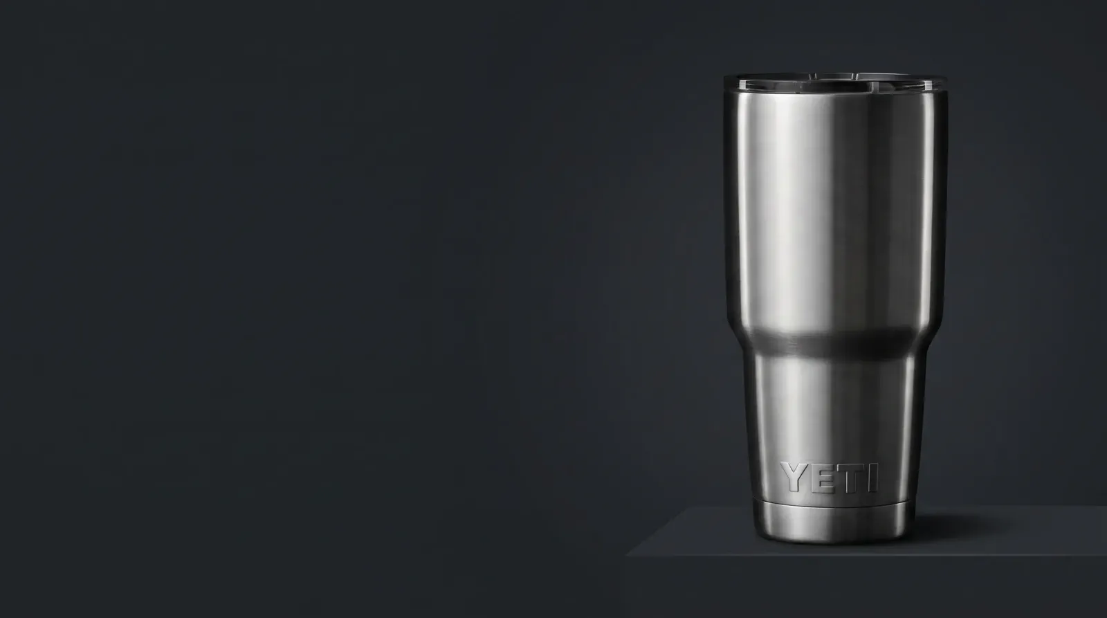 A reflective stainless tumbler anchors the right side of a wide commercial end frame with copy space on the left.
