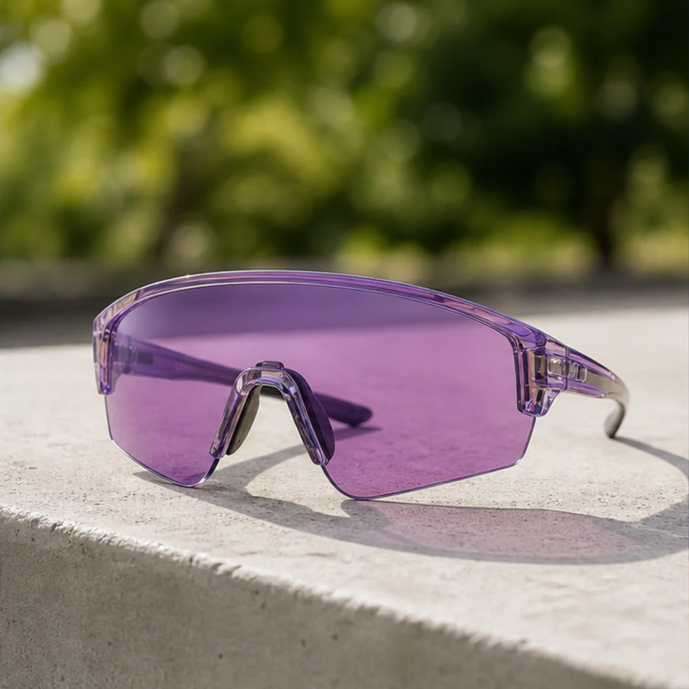 Violet cycling glasses placed in a sunlit outdoor setting.
